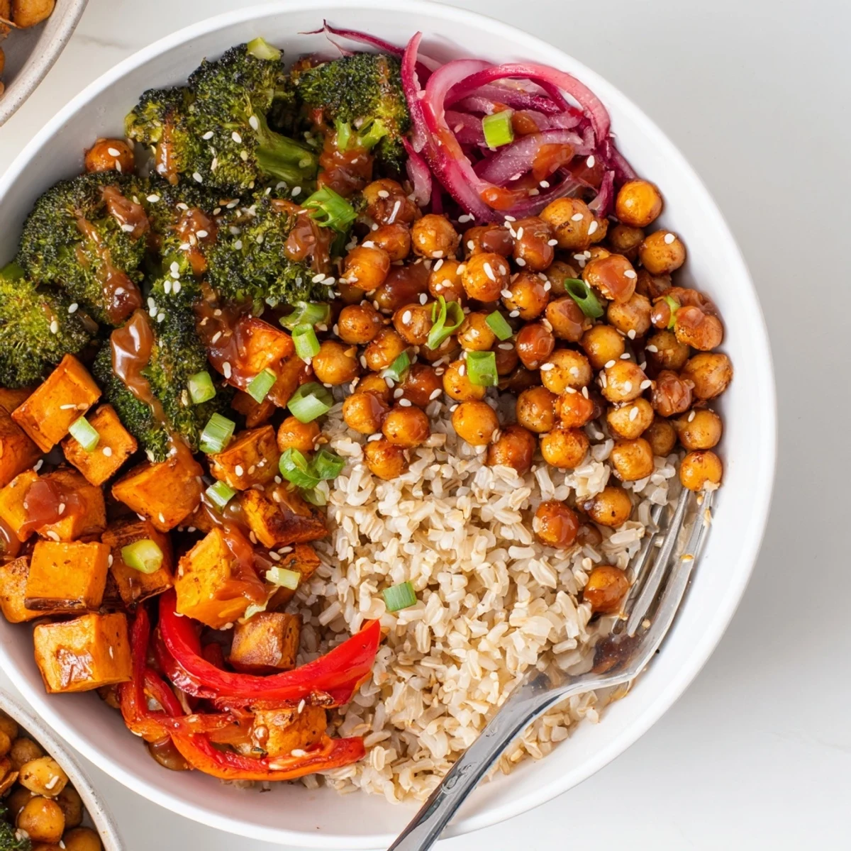 Vibrant bold sauce drizzle bowls topped with roasted veggies, chickpeas, and sauce drizzles.  