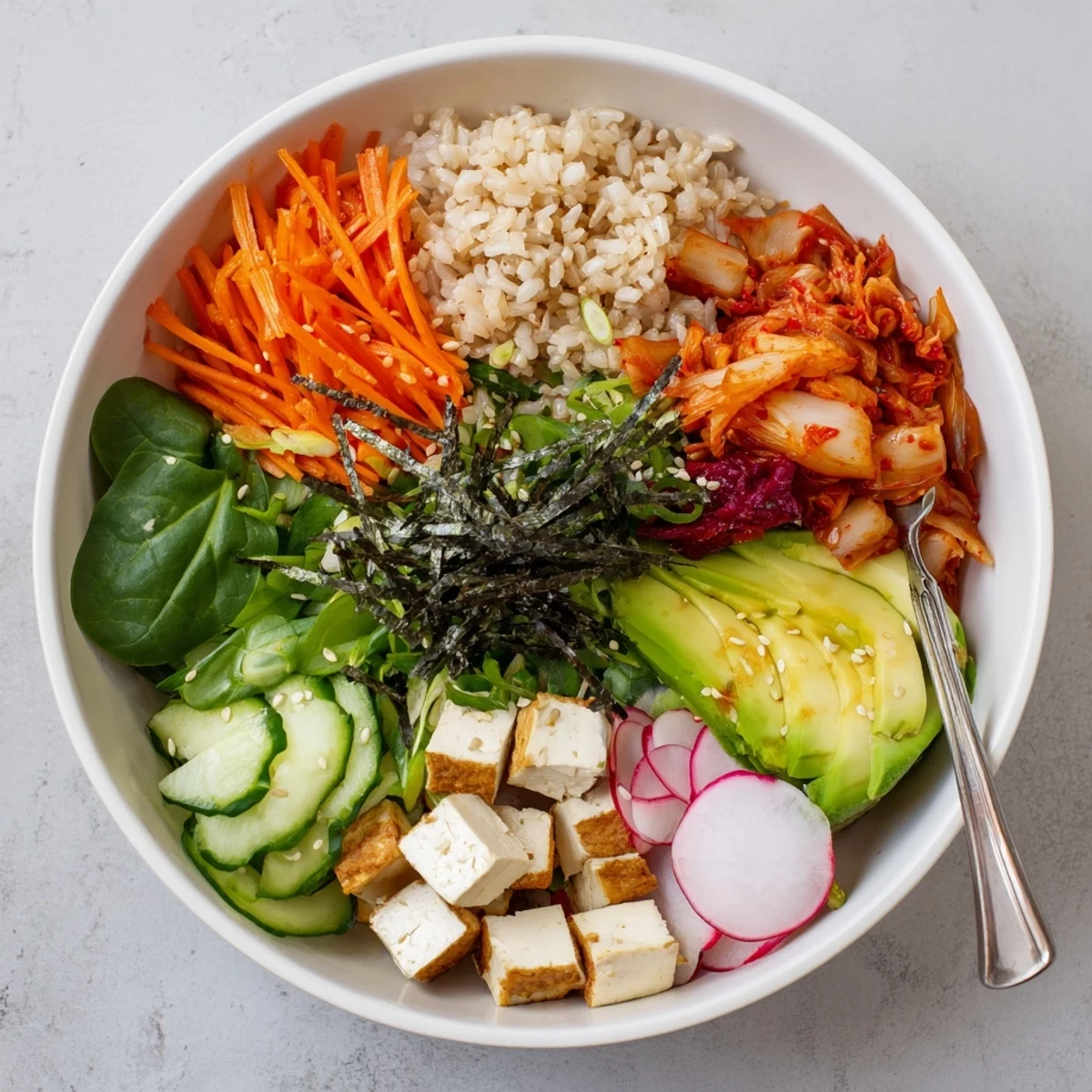 A colorful fermented vegetable bowl with kimchi, fresh greens, and creamy avocado.  