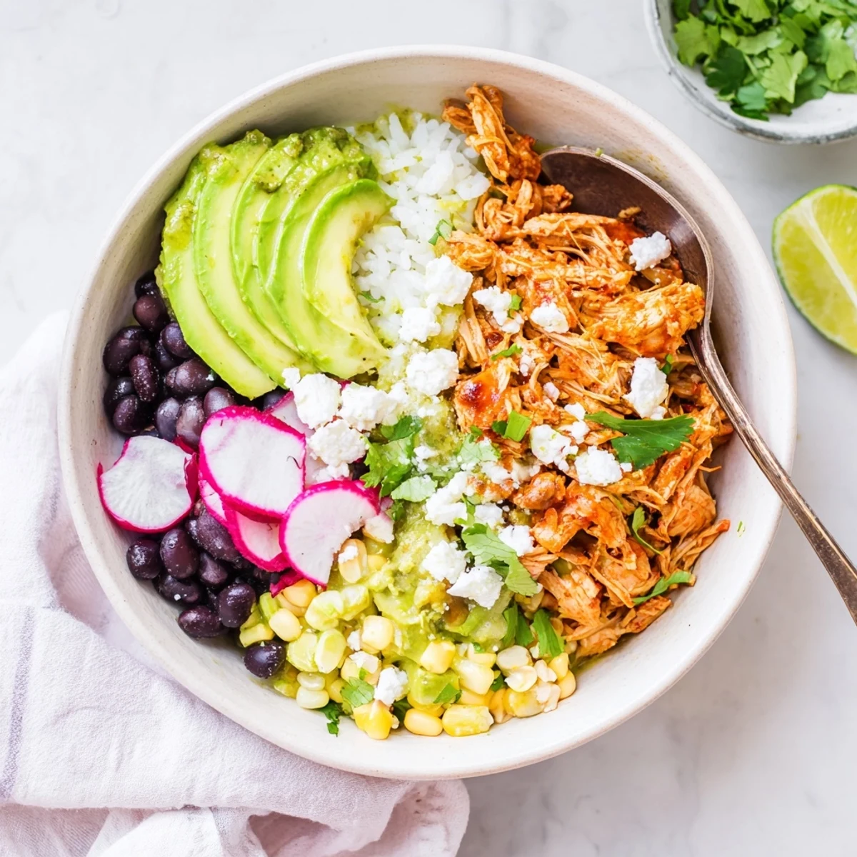 A colorful Green Enchiladas Rice Bowl topped with fresh cilantro and avocado slices.  