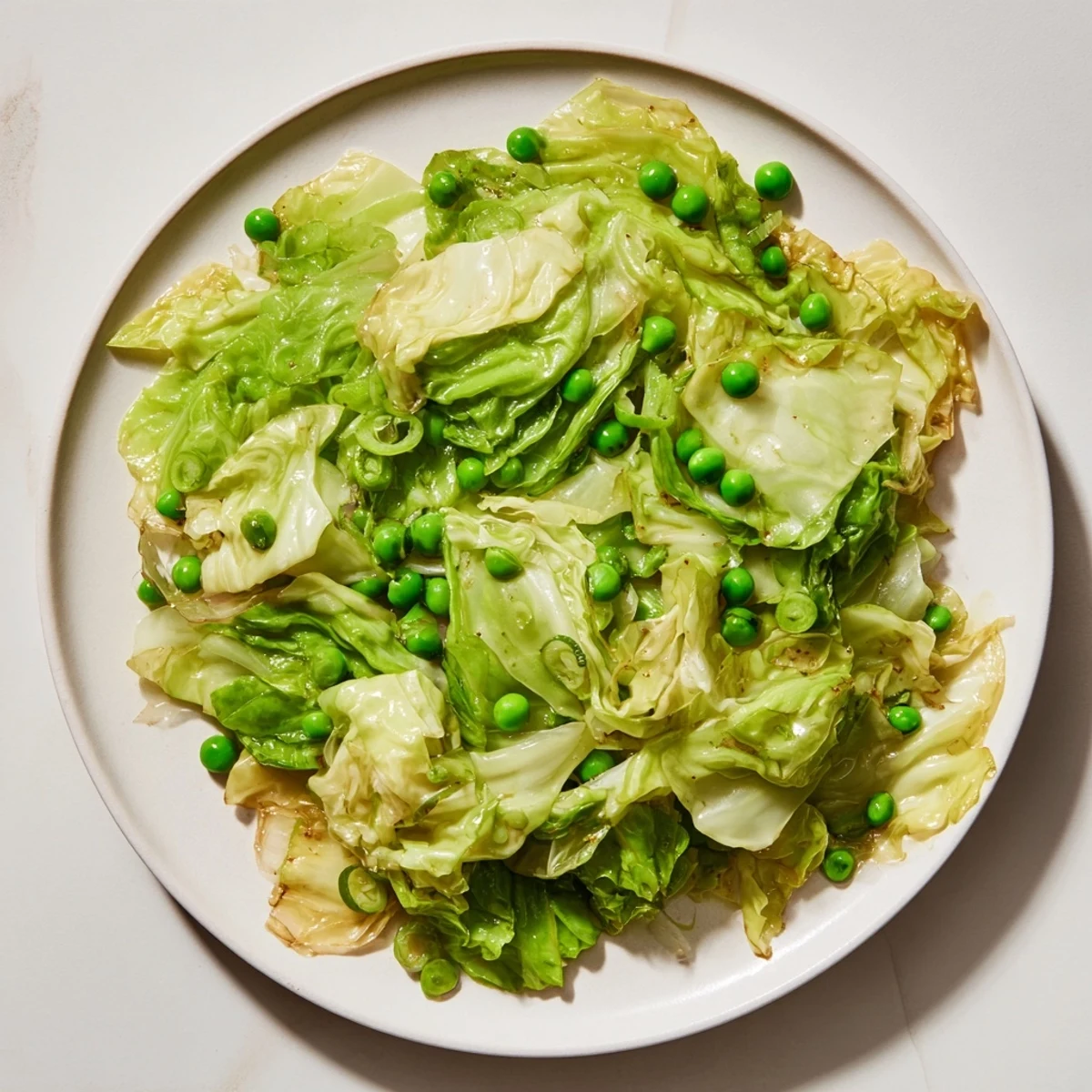 A fragrant bowl of Cabbage Stir-Fry featuring vibrant green peas and tender cabbage, ready to be enjoyed.