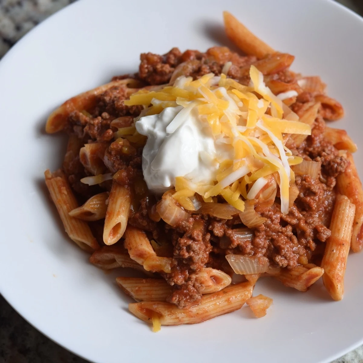 Savory Easy Beef Enchilada Pasta, a one-pot meal with melted cheddar on top.
