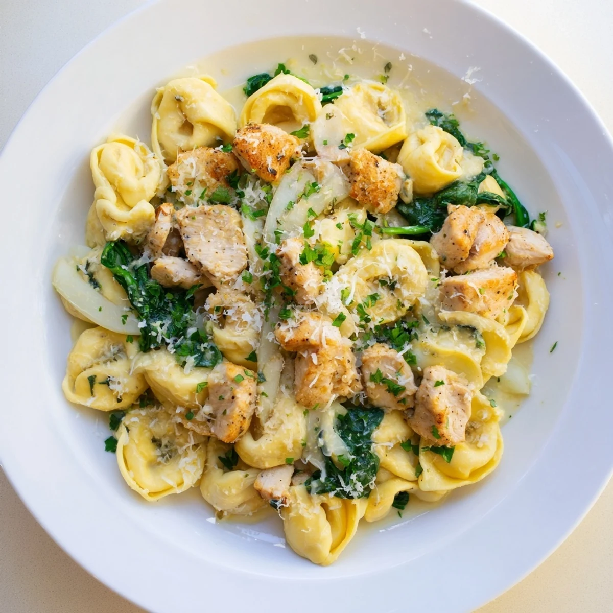 Fluffy cheese tortellini mingle with spinach and creamy sauce in this easy Creamy Chicken and Spinach Tortellini recipe.