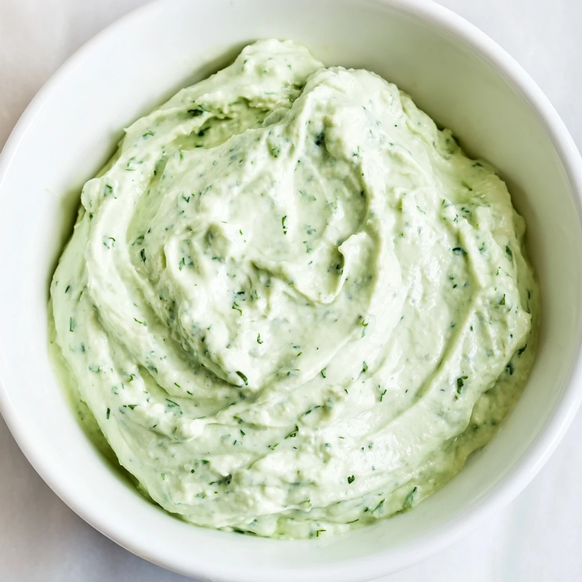 A bowl of fresh Green Goddess Dip, a delicious appetizer with bright green herbs, ready to enjoy.