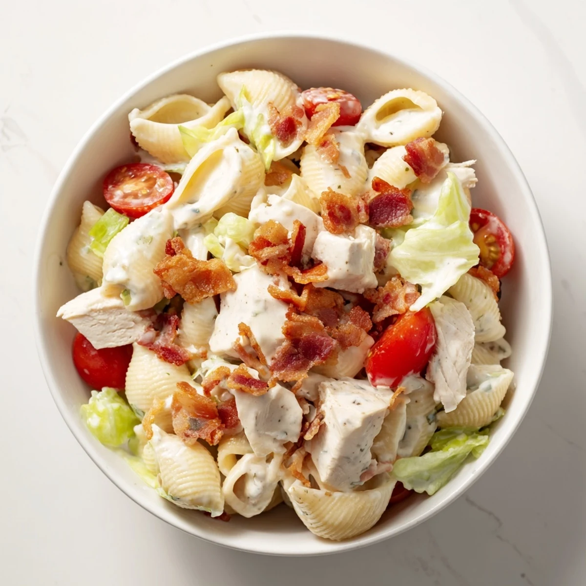 Creamy BLT Chicken Pasta Salad features crisp lettuce, juicy tomatoes, smoky bacon crumbles, and grilled chicken over tender pasta shells.
