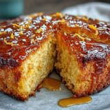 Slices of fragrant orange cake dusted with powdered sugar, showcasing a tender crumb and bright citrus zest in every bite.