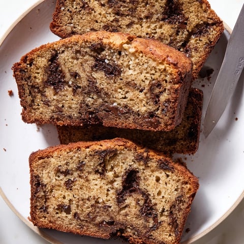 Moist Chocolate Chunk Banana Bread with melted chocolate glistening on top after baking.