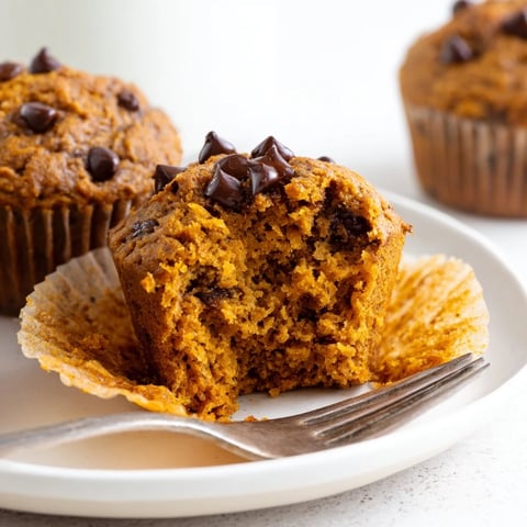 Moist vegan pumpkin chocolate chip muffins topped with warm, melted chocolate morsels.  