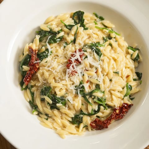 Creamy Tuscan Orzo Bowl with vibrant sun-dried tomatoes and spinach, a hearty vegetarian meal.