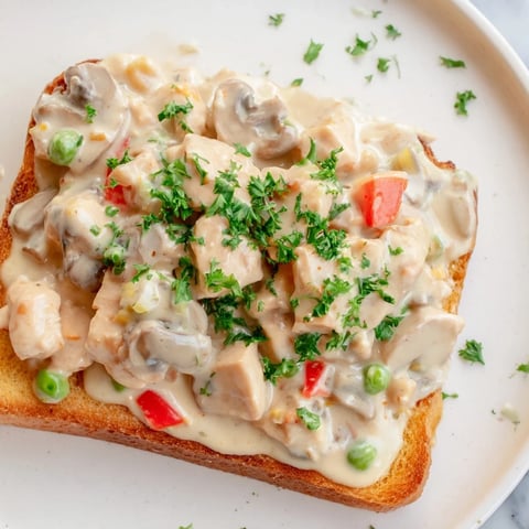 Creamy Chicken à la King over toast, a warm comfort dish with fluffy sauce on crisp toast.