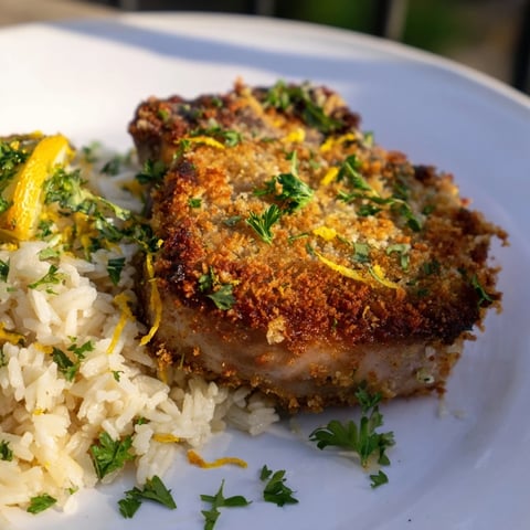 Golden, crispy Parmesan Herb Pork Chops served alongside fluffy rice, a satisfying dinner.