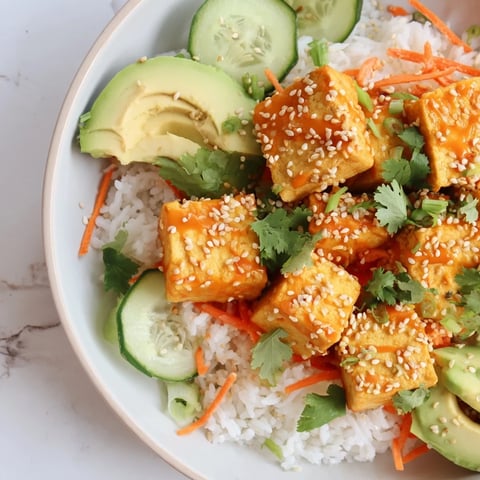 Chili-Mayo Baked Tofu Bowls: Crispy tofu cubes coated in spicy sauce, served over fluffy rice, a vibrant meal.