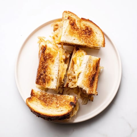 Golden, melted Gruyère and mozzarella oozing from a French Onion Grilled Cheese sandwich.