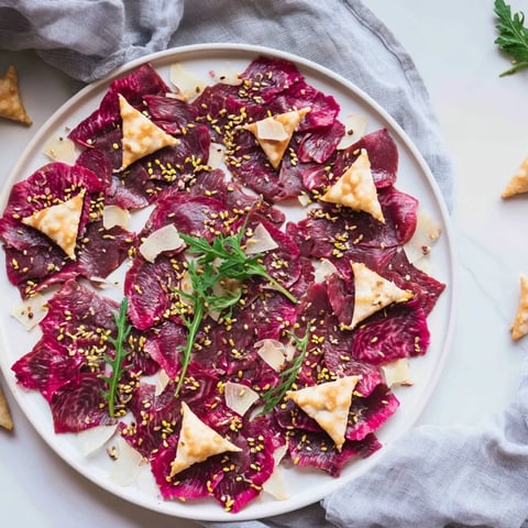 Delicate Origami Fold Beef Appetizer, arranged artfully with sesame seeds and Parmesan.