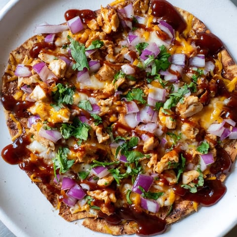Golden-crusted BBQ Chicken Flatbread, a delicious meal with melted cheese and fresh cilantro.
