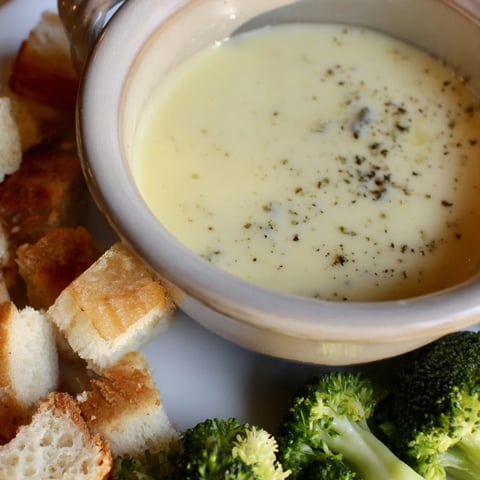 Warm, bubbling Swiss cheese fondue with crusty bread cubes ready for dipping and enjoying.