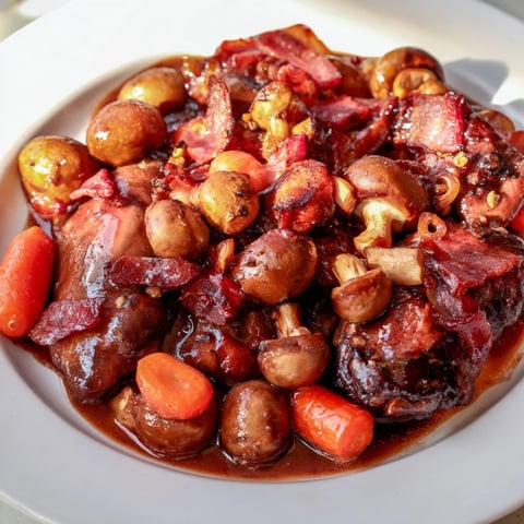 A close-up of Coq au Vin, showing tender chicken in a rich, red wine sauce.