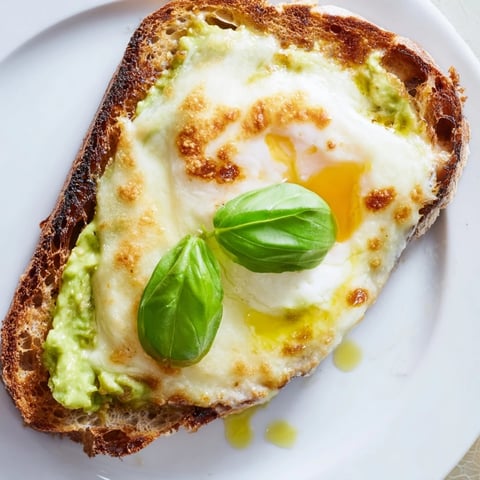 Creamy smashed avocado and melted mozzarella top a rustic sourdough slice for a savory tartine.  