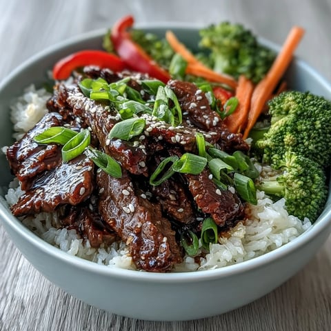 Tender beef slices glazed in teriyaki sauce, served over fluffy rice with crisp vegetables.