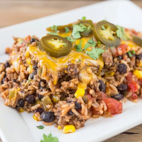 A close-up of a bubbling Tex-Mex Beef & Rice Casserole, savory with melted cheese and fresh herbs.