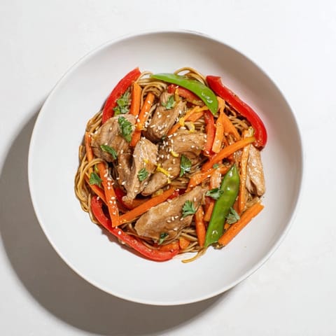 This photo shows a colorful, delicious Lemon-Garlic Chicken Stir Fry with Noodles, ready to serve and enjoy.