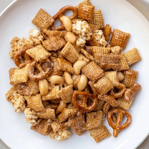 Sweet and salty Party Mix bursts with flavor, featuring a delicious sparkling cider glaze coating.