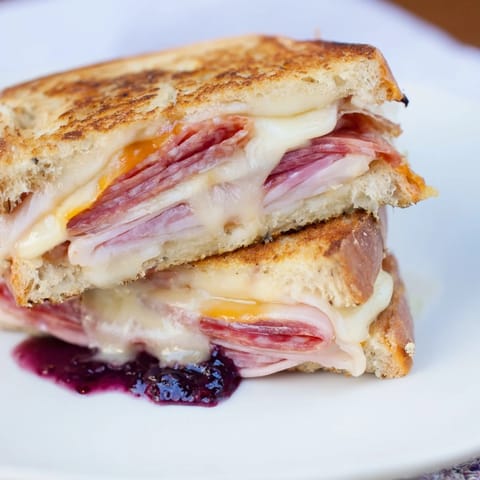 Crisp, delicious Charcuterie Grilled Cheese with layers of meat and cheese, ready to eat.