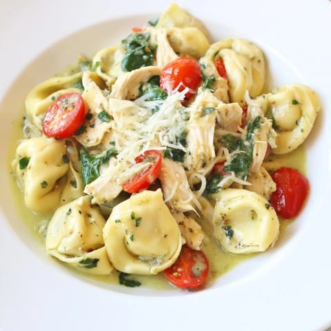 Creamy Pesto Tortellini Skillet with tender pasta, shredded chicken, and fresh spinach in a vibrant green sauce.