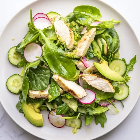 Colorful Spring Detox Chicken Salad in a white bowl features fresh avocado slices, perfect for a light lunch.