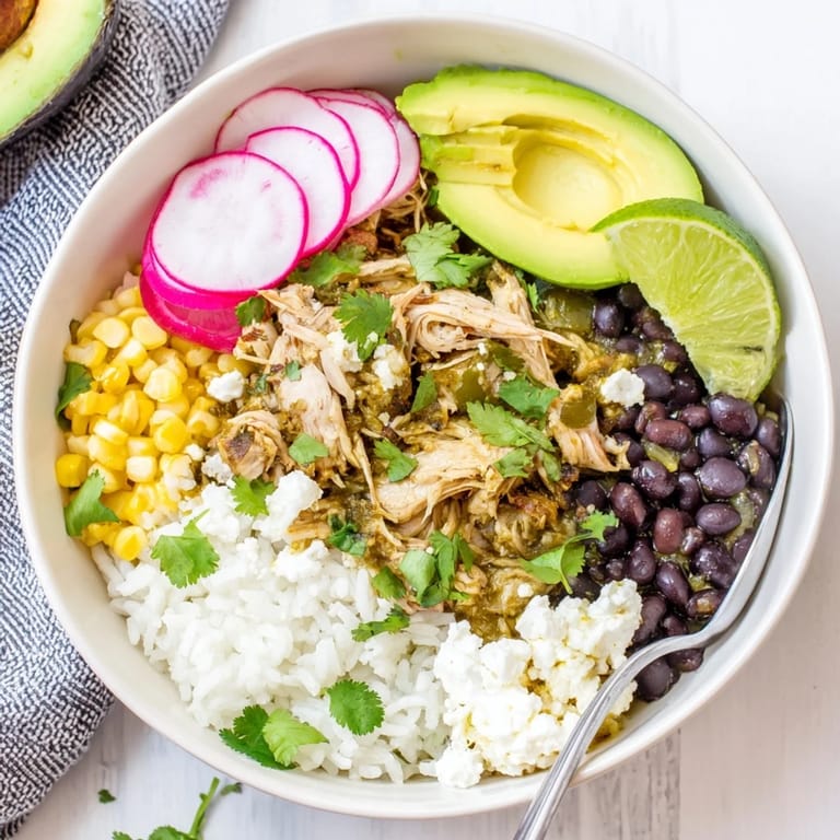 Savory Green Enchiladas Rice Bowl served with lime wedges and crumbled queso fresco.