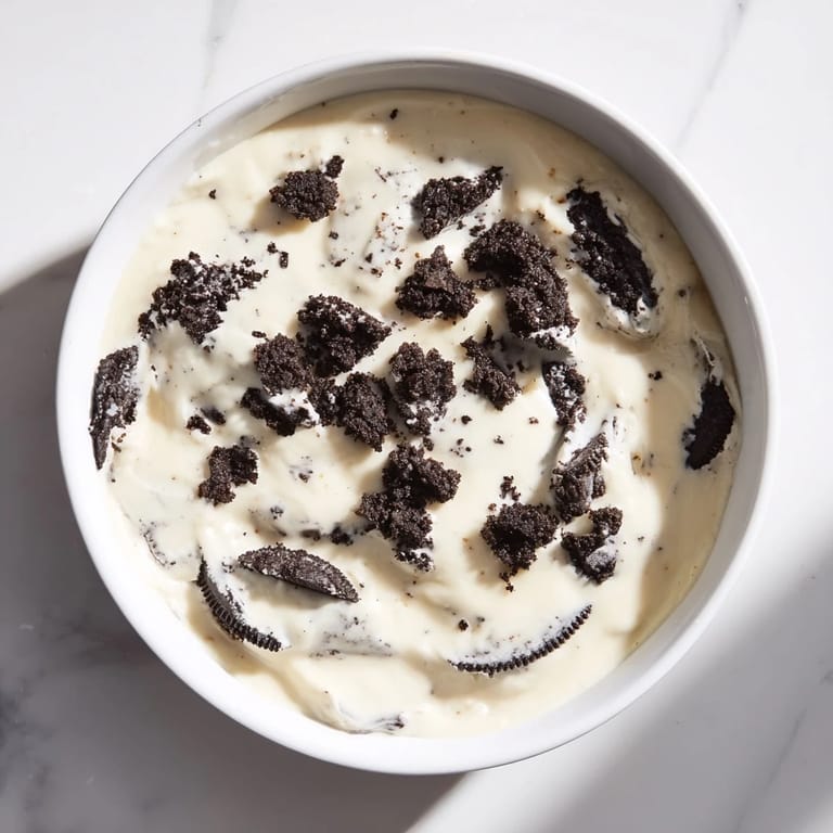 This decadent photo shows Vanilla Pudding with crushed Oreos, ready to eat, with a creamy, textured consistency.